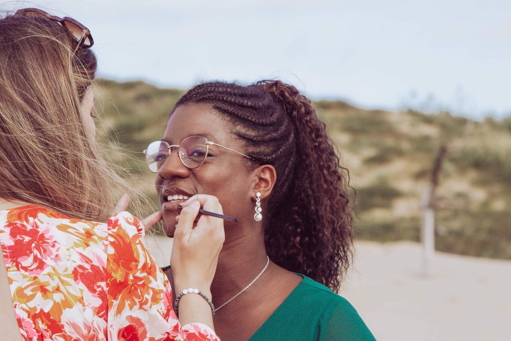 Morphologie visage Deux femmes interagissant de manière amicale sur une plage.
