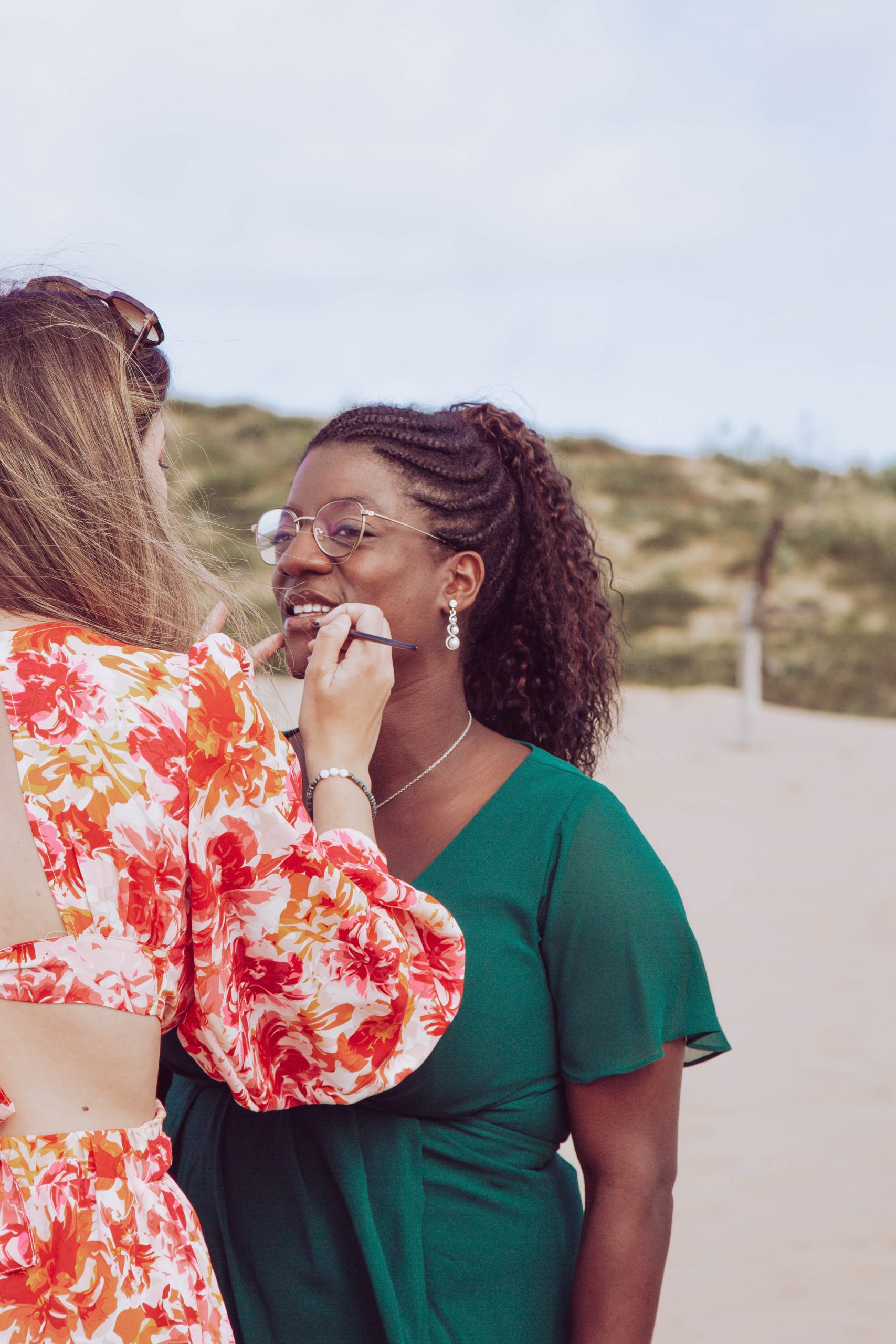 Morphologie visage Deux femmes interagissant de manière amicale sur une plage.